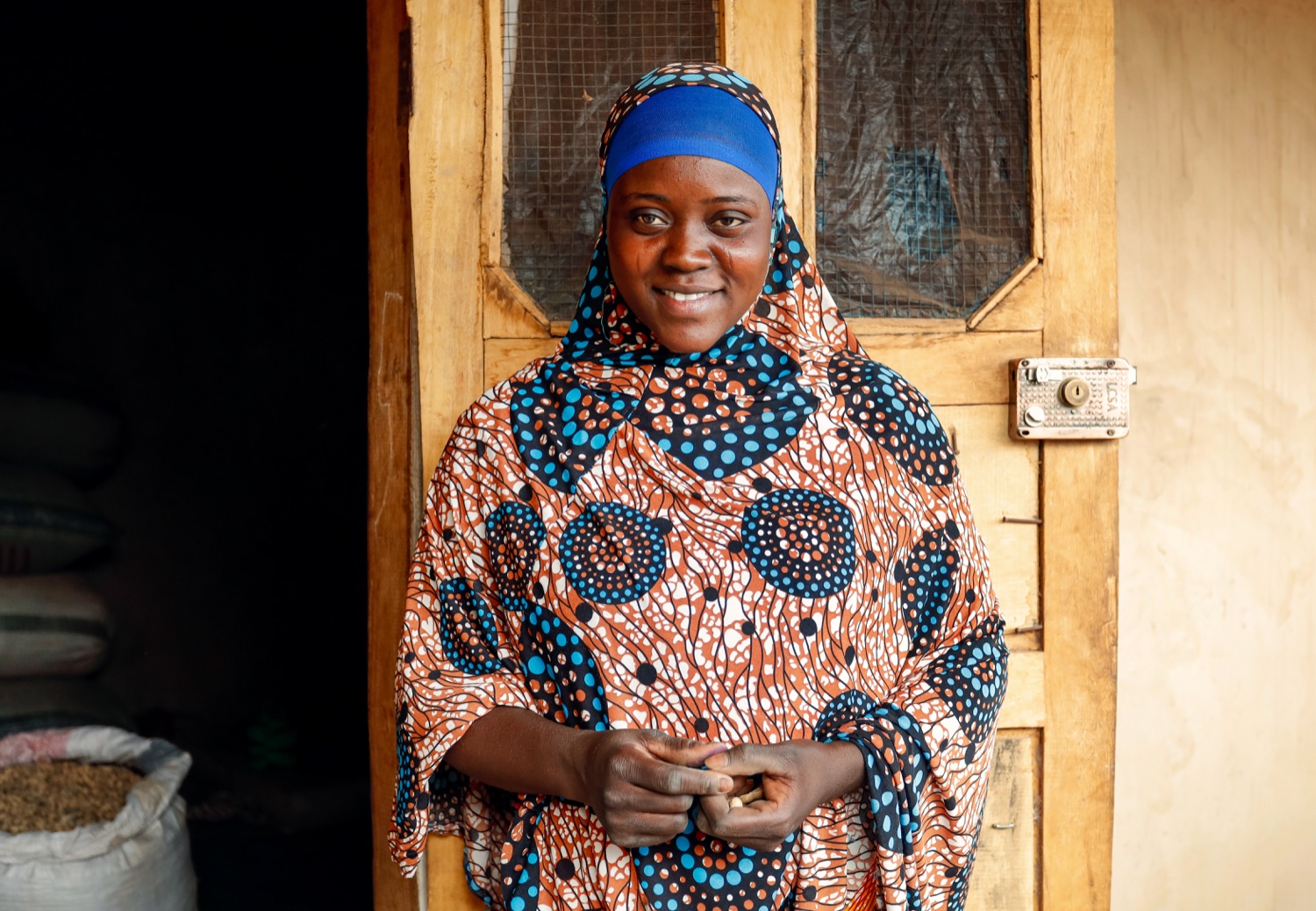 A woman standing at the doorway of her home